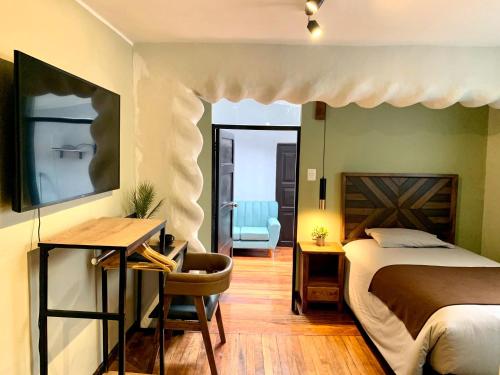 een slaapkamer met een bed, een bureau en een stoel bij Apartamentos Montes in Cuzco