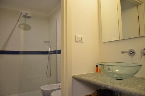 uma casa de banho com um lavatório e uma taça de vidro no balcão em Piazza Vittorio Suites em Turim
