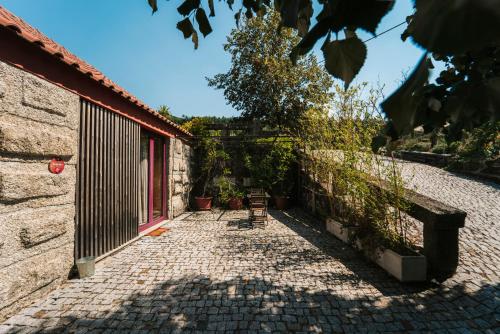 a brick walkway leading to a building with a fence at Peso Village in Amarante