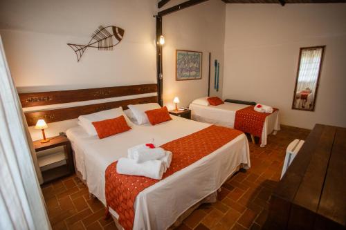 a hotel room with two beds with towels on them at Pousada Santu Noronha in Fernando de Noronha