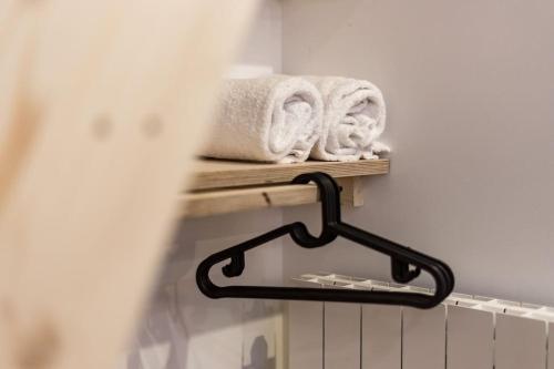 a towel rack with towels on a shelf in a bathroom at Studio proche cité internationale in Caluire-et-Cuire