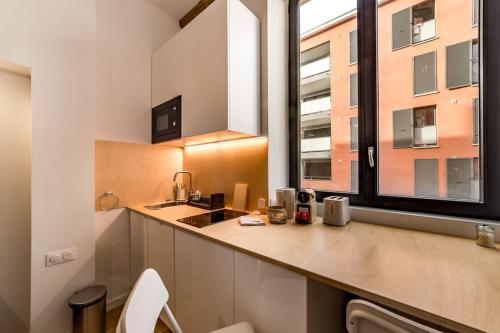 une cuisine avec un évier et une grande fenêtre dans l'établissement Studio proche cité internationale, à Caluire-et-Cuire