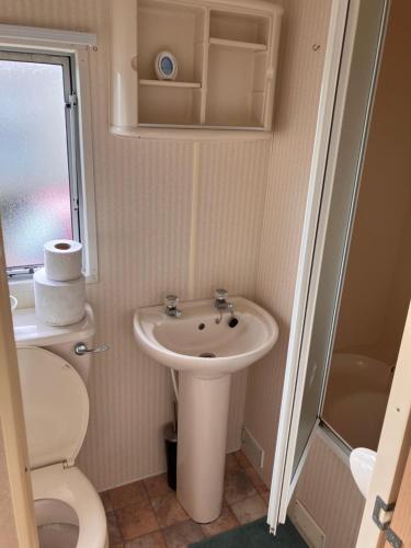 uma pequena casa de banho com lavatório e WC em Coastal Getaway, camber sands em Camber