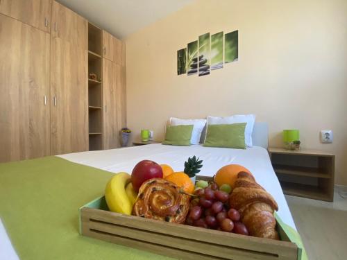 a tray of fruit on a bed in a room at Park apartment - Stara Zagora in Stara Zagora