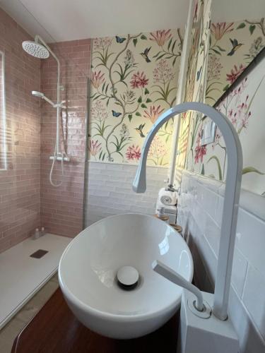 La salle de bains est pourvue d'un lavabo blanc et d'une douche. dans l'établissement Casa A la orilla del Valcorba, à Santibáñez de Valcorba
