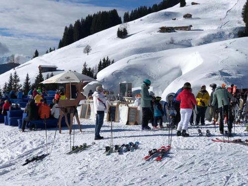 a group of people standing around in the snow at Pension Kaiserstubn in Söll