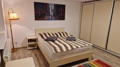 een slaapkamer met een bed met een gestreepte deken bij Casa Teo in Buzau