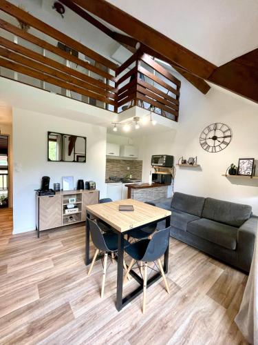 un salon avec une table et un canapé dans l'établissement Duplex du Pailhet, T3 neuf, vue montagne, parking, navette et 2 vélos à disposition gratuitement, à Luchon