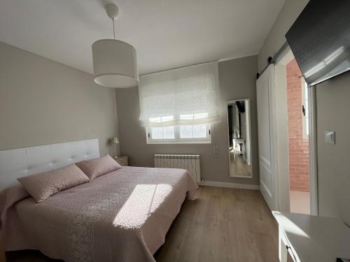 una camera da letto con un letto grande e una finestra di Casa A la orilla del Valcorba a Santibáñez de Valcorba