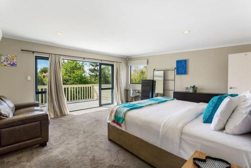 - une chambre avec un grand lit et un balcon dans l'établissement Ultimate 5-Bedroom Rural Poolside Oasis - Auckland, à Albany