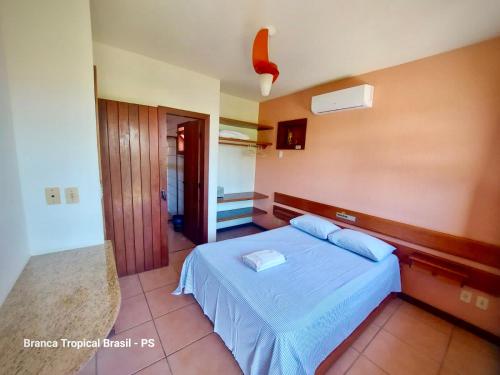 1 dormitorio con 1 cama azul en una habitación en Branca Tropical Brasil Residencial- Taperapuan, en Porto Seguro