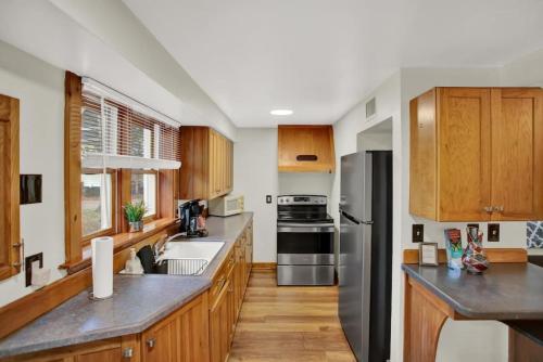 a kitchen with wooden cabinets and stainless steel appliances at Belong Downtown 1br 1ba in Gainesville