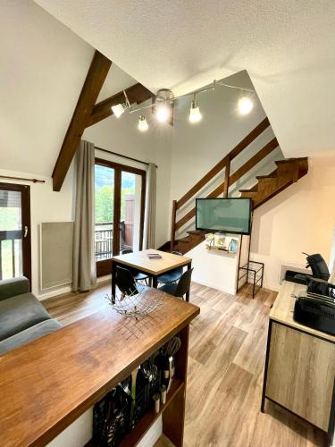 un salon avec un canapé et une table dans l'établissement Duplex du Pailhet, T3 neuf, vue montagne, parking, navette et 2 vélos à disposition gratuitement, à Luchon