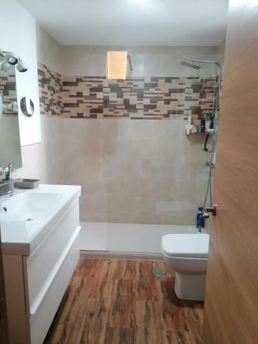 ein Badezimmer mit einem weißen Waschbecken und einem WC in der Unterkunft El descanso in Mairena del Aljarafe