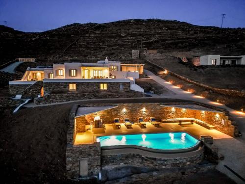 a villa with a swimming pool at night at Alos Residence in Agios Romanos