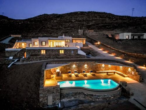 une villa avec piscine la nuit dans l'établissement Alos Residence, à Agios Romanos