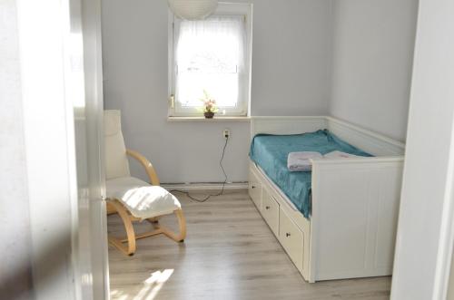 a small bedroom with a bed and a chair at Ferienhaus Erika in Geringswalde