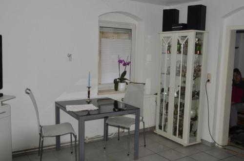 un comedor con mesa y sillas y un armario con botellas de vino en Ferienhaus Erika, en Geringswalde