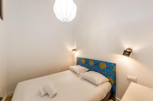 a white bed with two pillows in a room at Grand T2 avec balcon • proche parc de la Tête d'Or in Caluire-et-Cuire