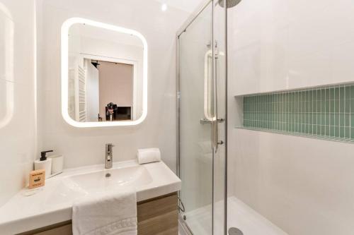 a white bathroom with a sink and a shower at Grand T2 avec balcon • proche parc de la Tête d'Or in Caluire-et-Cuire