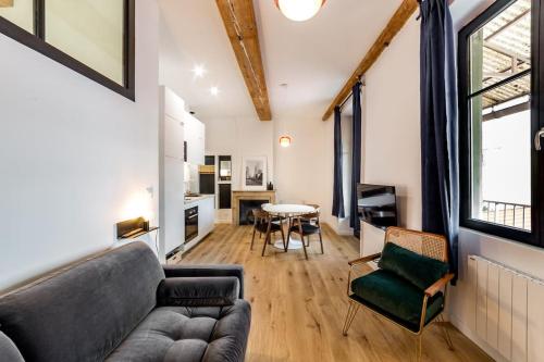 un salon avec un canapé et une table dans l'établissement Grand T2 avec balcon • proche parc de la Tête d'Or, à Caluire-et-Cuire