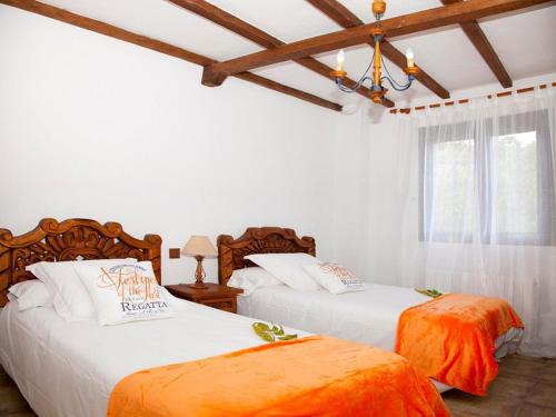 2 Betten in einem Schlafzimmer mit weißen Wänden und Holzdecken in der Unterkunft Alojamiento Rural Villanueva del Conde in Villanueva del Conde