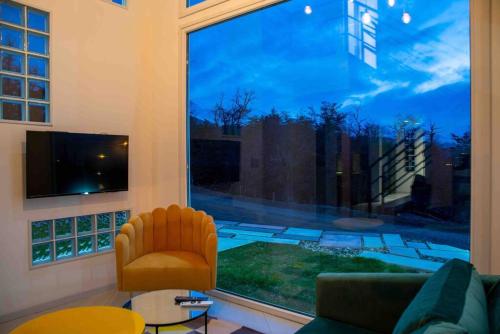 sala de estar con ventana grande con sofá y silla en Miradores del Susana Duplex III en Ushuaia