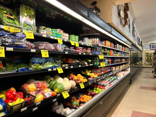 a grocery store aisle filled with lots of fruits and vegetables at Hotel Carmacks in Carmacks