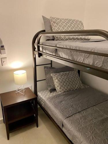 a bedroom with two bunk beds and a table with a lamp at CASA SAHUARO con alberca privada, Col El Mirador in San Carlos