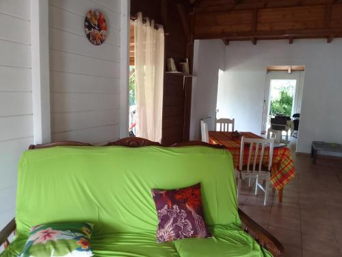 a green couch in a living room with a table at Malaka Rose in Sainte-Rose