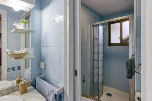 a blue bathroom with a shower and a sink at Can Mateuet - House Rental by Season in Llagostera