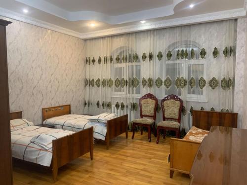 ein Krankenhauszimmer mit 2 Betten und 2 Stühlen in der Unterkunft Laola民宿 in Almaty