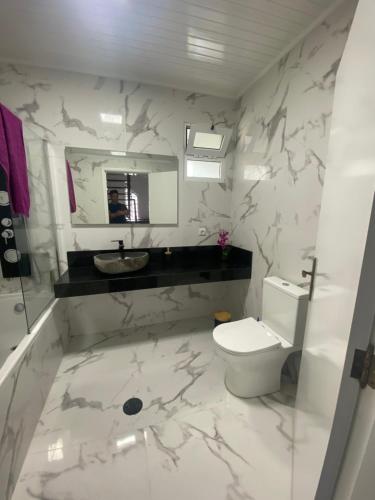 a bathroom with a toilet and a sink and a mirror at Hollywood villa in Campanário