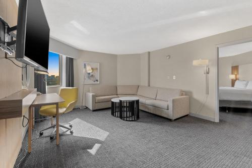 a hotel room with a couch and a desk and a tv at Crowne Plaza Houston Med Ctr-Galleria Area by IHG in Houston