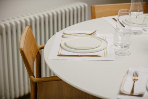 a white table with a plate and glasses on it at The Church Tower in Crieff