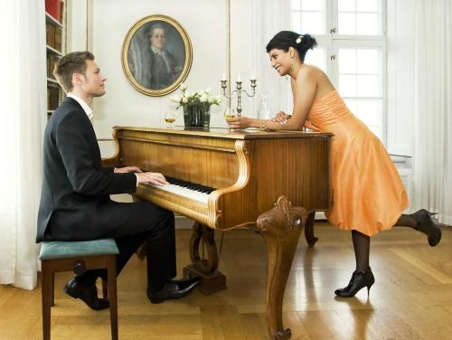 a man and a woman playing a piano at Mauritzbergs Slott & Golf in Mauritsberg