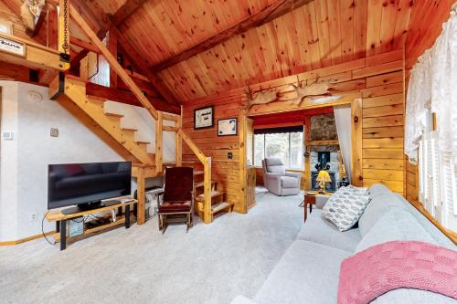 a living room with a couch and a tv in a cabin at Lily Bay Getaway in The Highlands