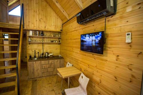 a room with a wooden wall with a table and a television at Woodpecker Georgia in Batumi