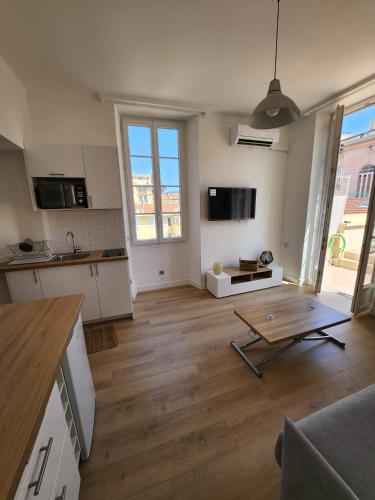 Il comprend une grande cuisine et un salon avec une table. dans l'établissement AMAZING STUDIO - GRANDE TERRASSE - COEUR DE VILLE - WIFI - AC, à Nice