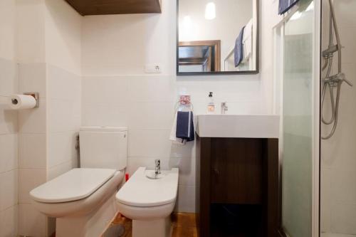 a white bathroom with a toilet and a sink at Central, near the Alhambra, quiet and autentic! in Granada