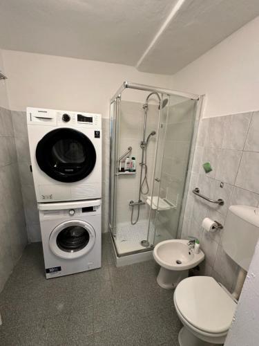 Un baño con lavadora y un inodoro. en Annina home, en Turín