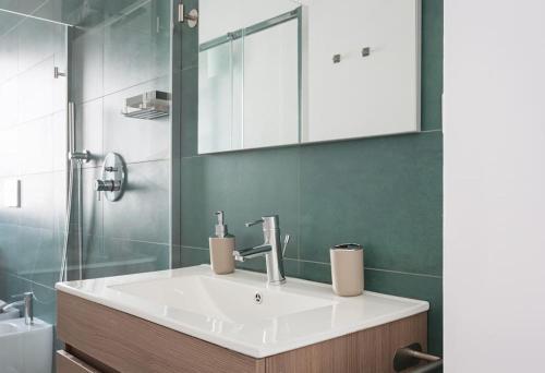 a bathroom with a white sink and a mirror at Moderno, luminoso, spazioso con VISTA in Milan