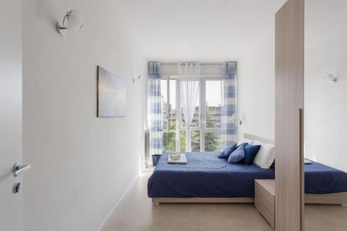 a bedroom with a blue bed and a window at Moderno, luminoso, spazioso con VISTA in Milan