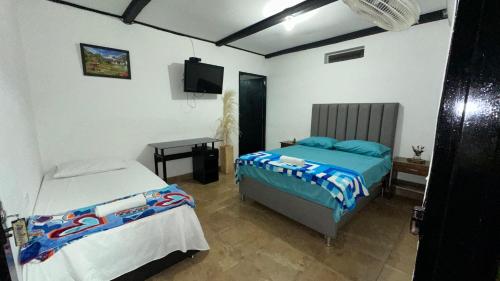 - une chambre avec 2 lits et une télévision dans l'établissement Finca hotel Rios Claros, à San Luis