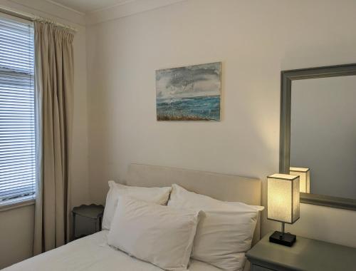 una camera da letto con un letto con cuscini bianchi di Quirky Coach House a Plymouth