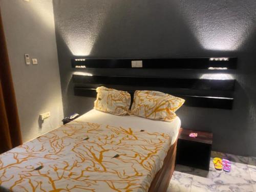 1 dormitorio con 1 cama con cabecero negro en Sunrise Center Bonapriso 104, en Douala