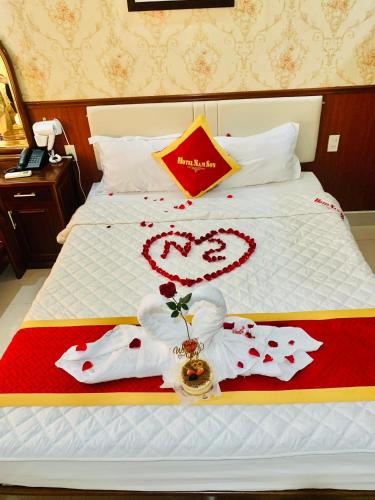 a bed with red and white decorations on it at Khách Sạn Nam Sơn in Ðông Khê