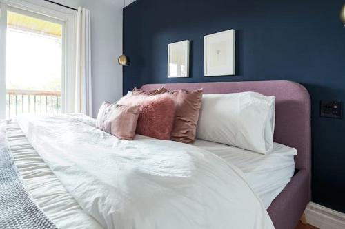 a white bed with pillows on it in a bedroom at Grays Lane - Minutes to Sandbanks in Bloomfield