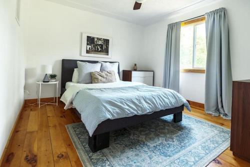 a bedroom with a bed with a blue blanket and a window at Grays Lane - Minutes to Sandbanks in Bloomfield