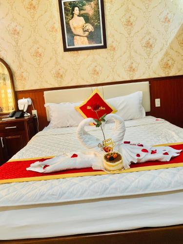 a hotel bed with a tray with a cake and an umbrella at Khách Sạn Nam Sơn in Ðông Khê